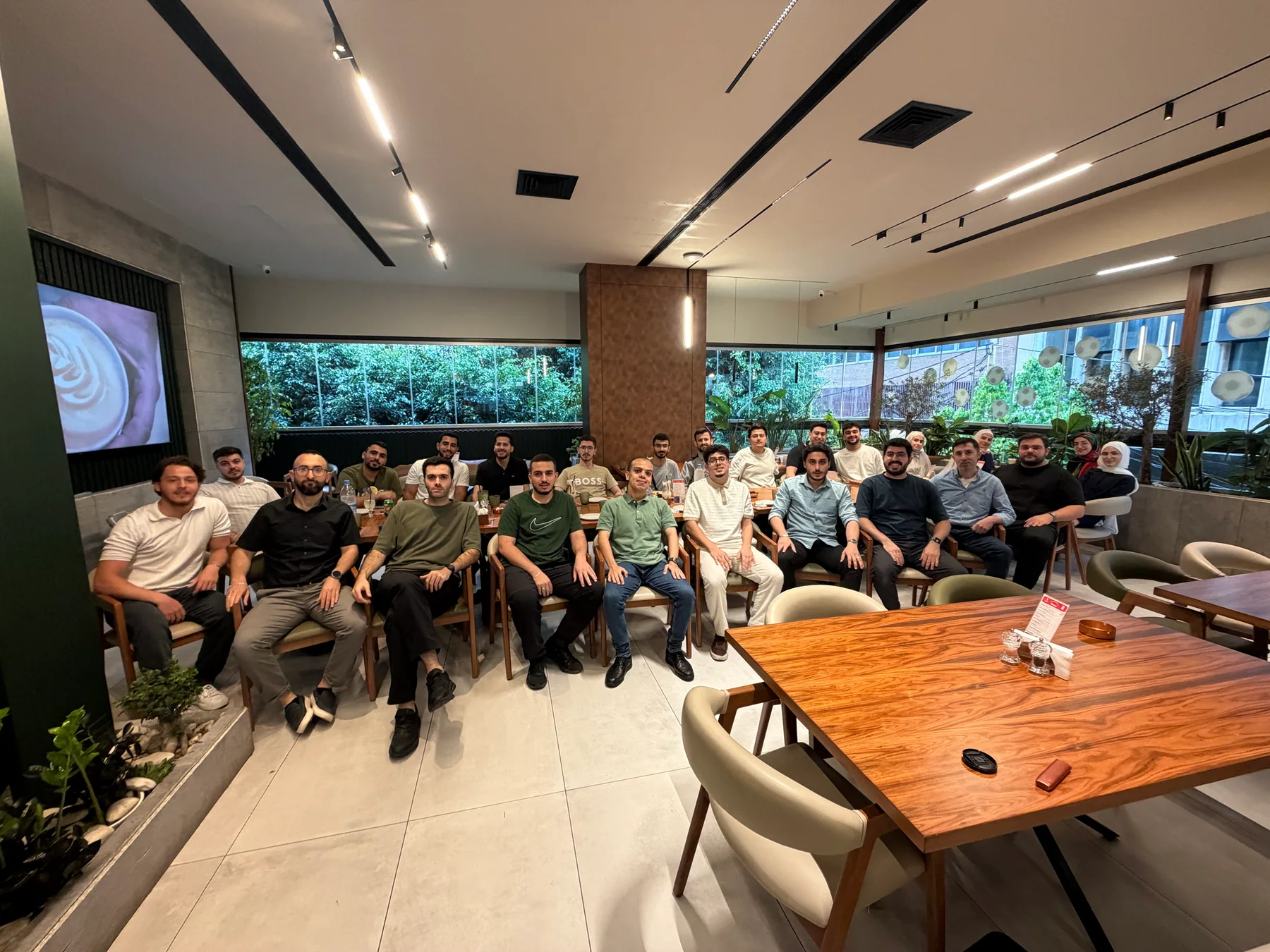 About two dozen Lebanese in AI members posing together at a Beirut restaurant