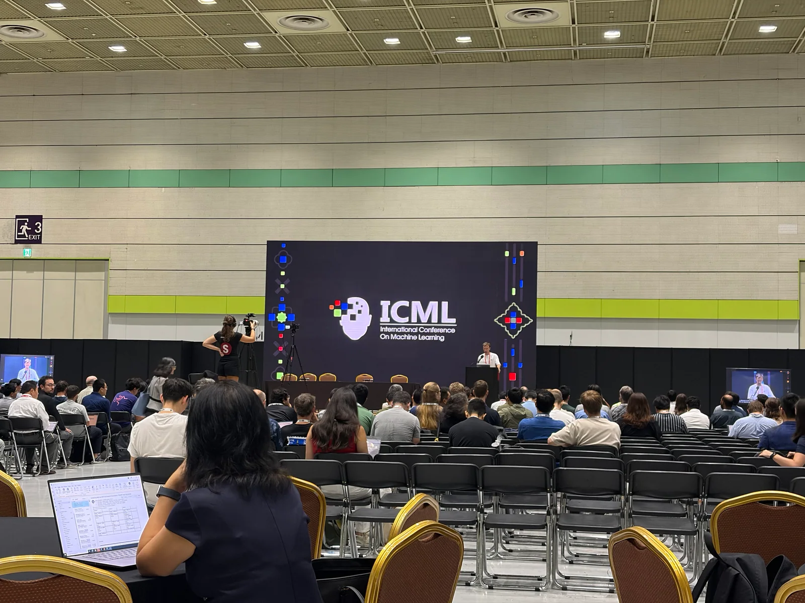 Conference audience facing the main stage at ICML 2026