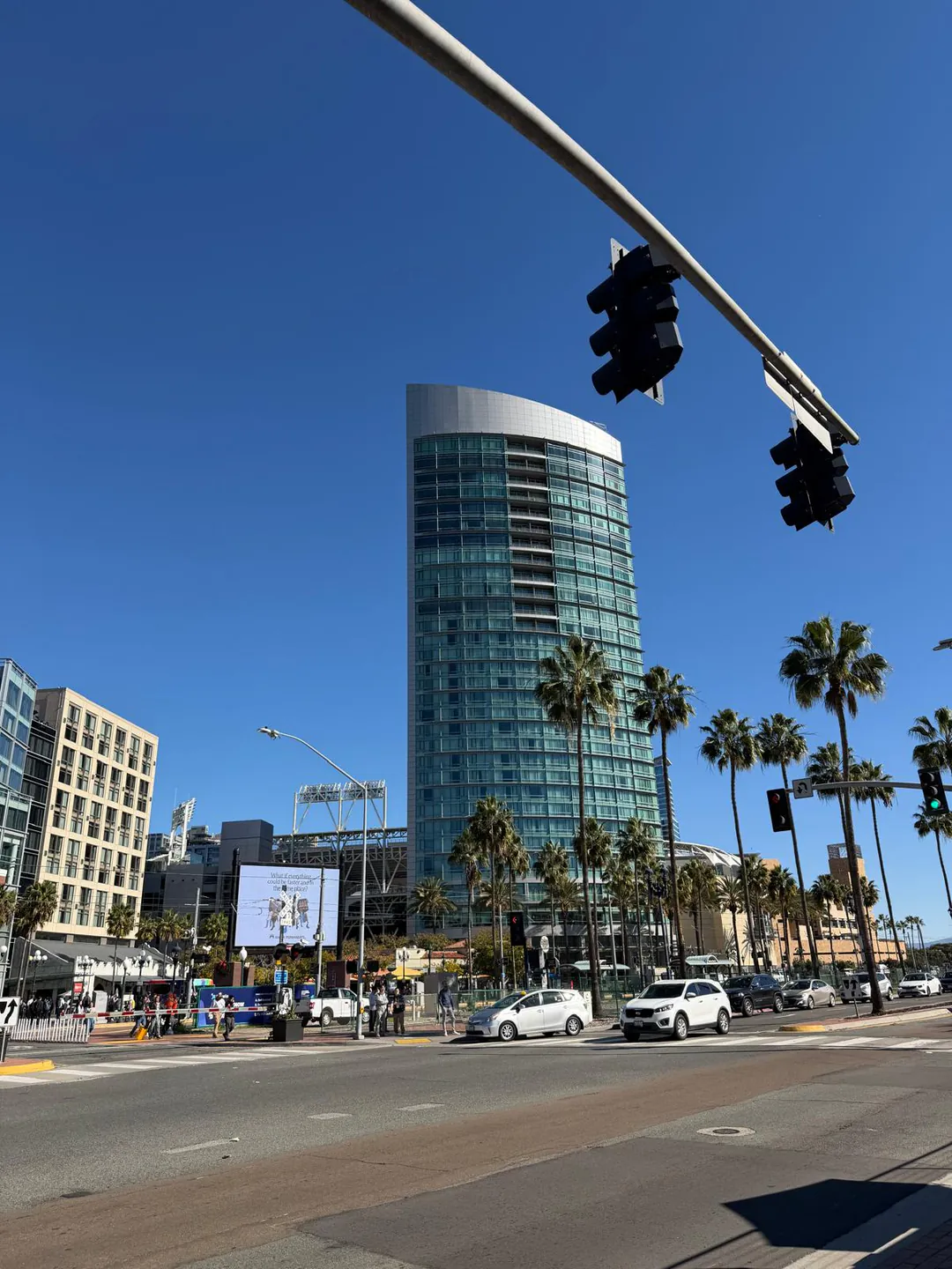 A palm-lined downtown San Diego intersection beneath a clear blue sky